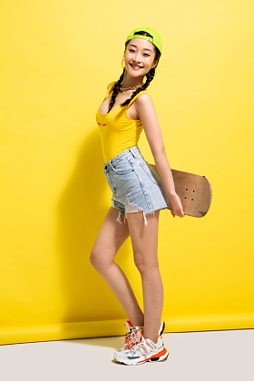 漂亮的青年女人拿着滑板图片