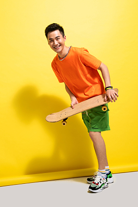 拿着滑板的快乐青年男人图片