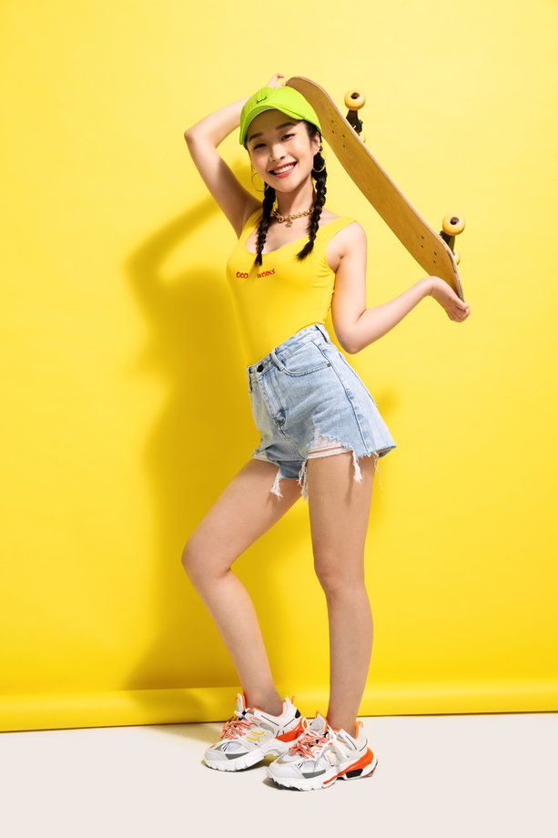 快乐的青年女人举着滑板 快乐的青年女人举着滑板