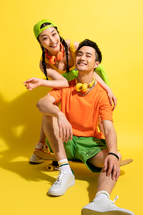 青年伴侣坐着交流滑板运动图片