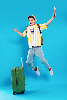 举着机票护照旅行的年轻男人图片