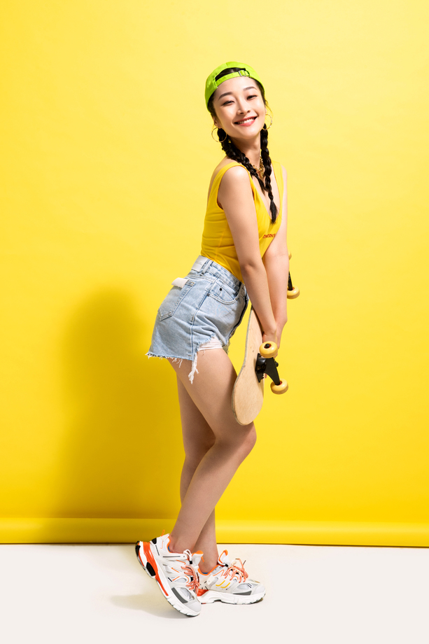 漂亮的青年女人抱着滑板 漂亮的青年女人抱着滑板