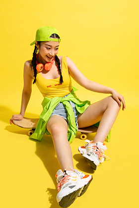 坐在滑板上休息的青年女人图片