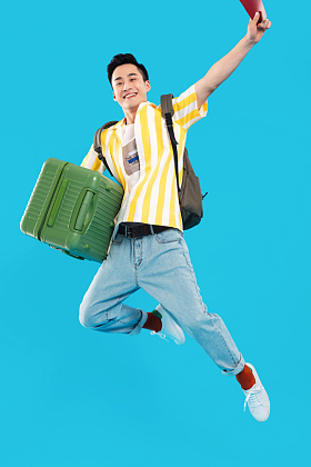 抱着行李箱去旅行的年轻男人图片