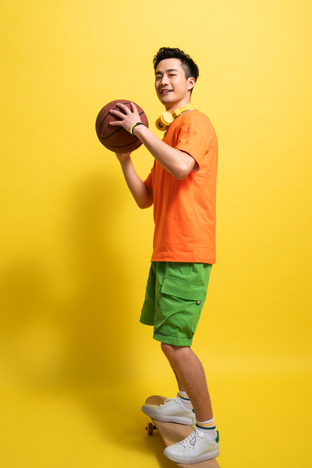 拿着篮球滑着滑板的青年男人图片