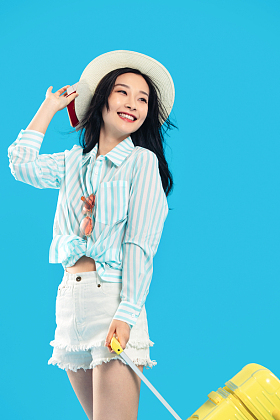 拉着行李箱出发去旅行的年轻女人