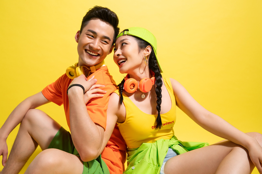 背靠背坐着聊天的时尚青年情侣