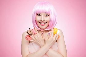 手指夹满马卡龙的时尚女孩图片