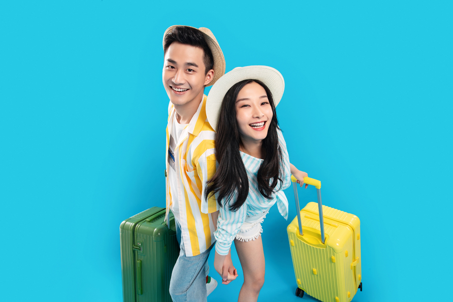 快乐的青年情侣拉着行李箱去旅游 快乐的青年情侣拉着行李箱去旅游