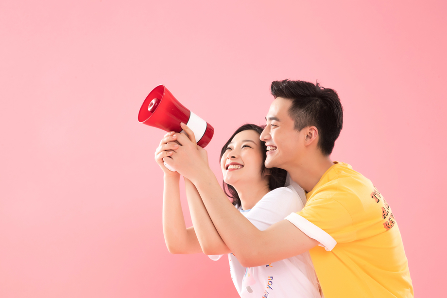 时尚青年伴侣举着扩音器