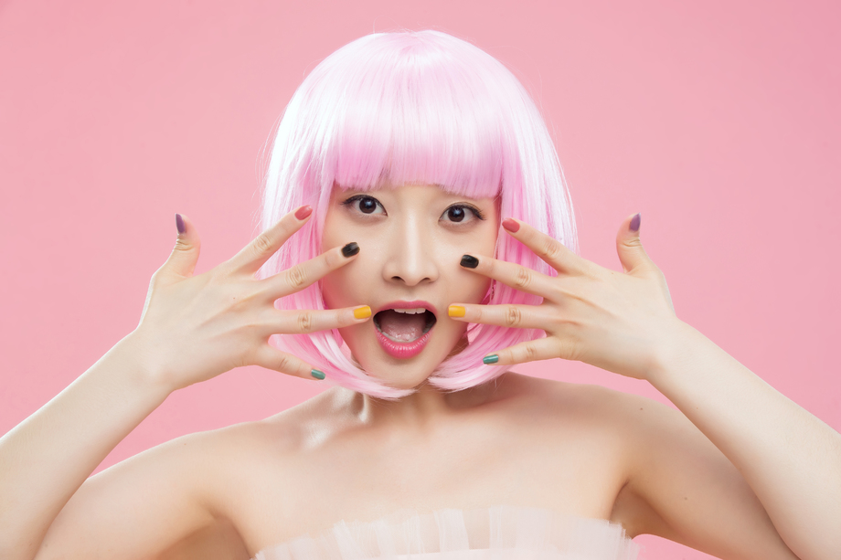 展示彩色指甲油的时尚年轻女人