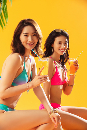 快乐闺蜜在沙滩上喝饮料图片