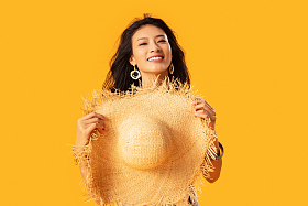 拿着遮阳帽的快乐女人肖像图片
