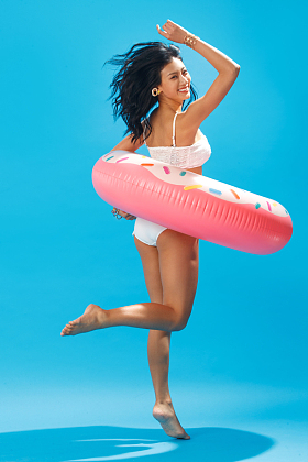 比基尼美女套着游泳圈跳跃