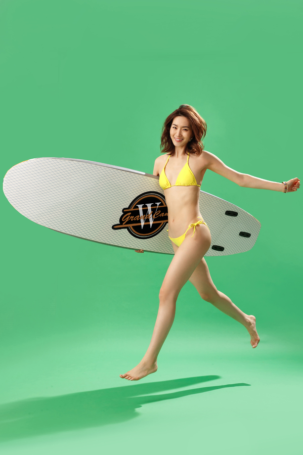 快乐的青年女人抱着冲浪板图片