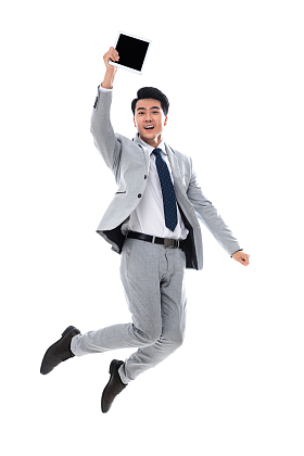 拿着平板电脑跳跃的商务男士图片
