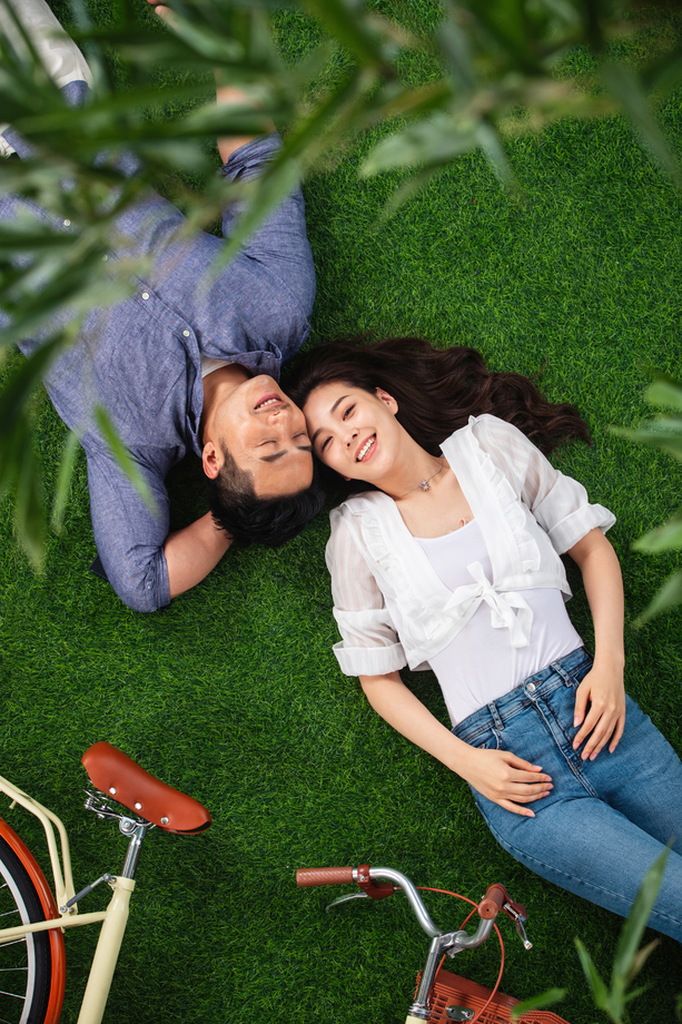 甜蜜的青年伴侣躺在草地上 甜蜜的青年伴侣躺在草地上