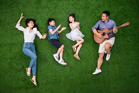 幸福的一家四口在草地上唱歌图片