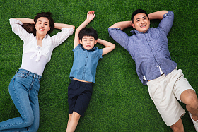 幸福的一家三口躺在草地上图片