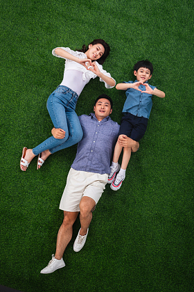 在草地上青年男人驮着妻子和儿子