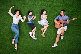 幸福的一家四口在草地上唱歌图片