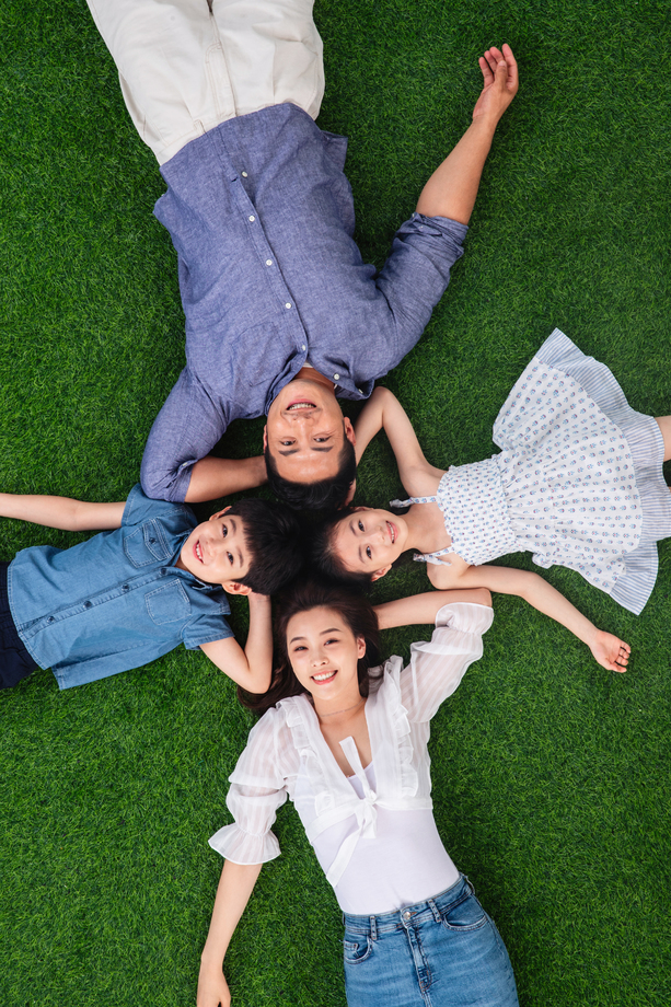 幸福的一家四口躺在草地上