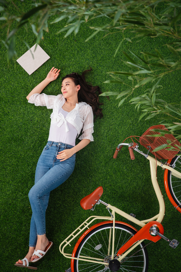 躺在草地上享受大自然的青年女人 躺在草地上享受大自然的青年女人