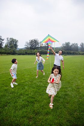 快乐的一家四口在草地上放风筝