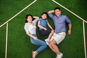 快乐的一家三口躺在草地上的房子轮廓