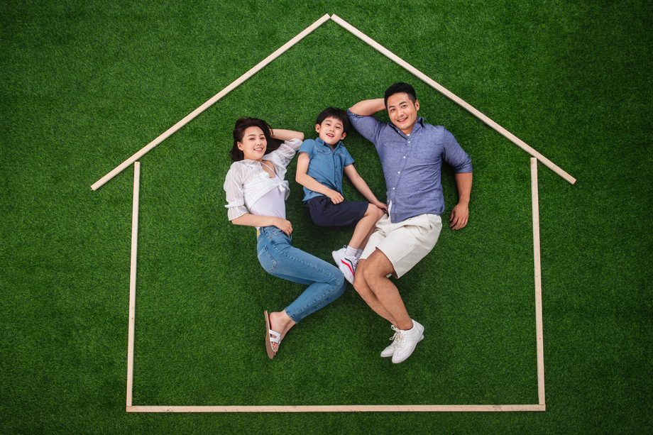 快乐的一家三口躺在草地上的房子轮廓