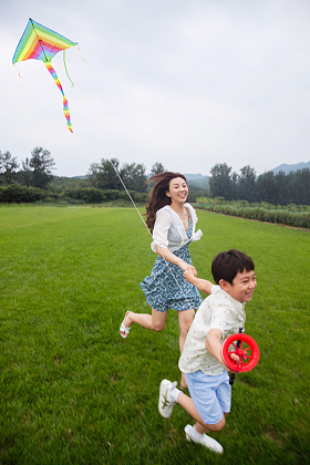 快乐的母子在草地上放风筝图片