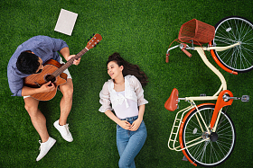 幸福的青年伴侣在草地上享受快乐时光