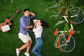 幸福的青年伴侣躺在草地上享受甜蜜时光