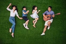 幸福的一家四口在草地上唱歌图片