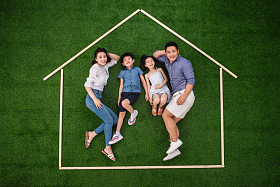 快乐的一家四口躺在草地上的房子轮廓