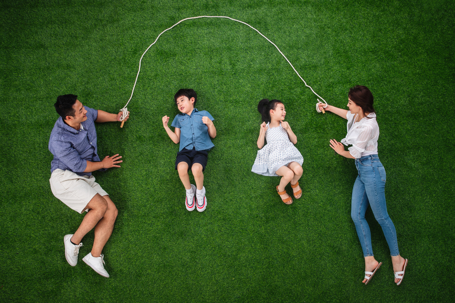 快乐的一家四口在草地上跳绳