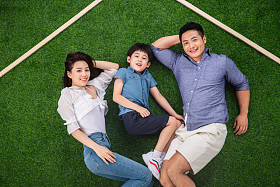 快乐的一家三口躺在草地上的房子轮廓