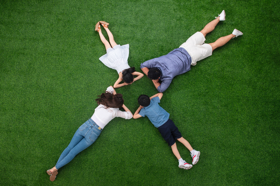 幸福的一家四口趴在草地上图片