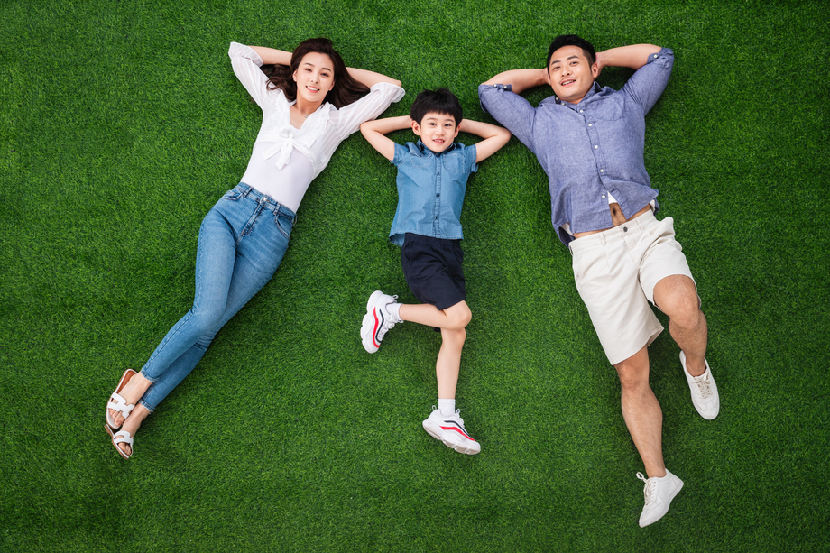 幸福的一家三口躺在草地上图片