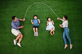 快乐的一家四口在草地上跳绳图片