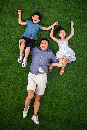 在草地上父亲托举儿子和女儿图片