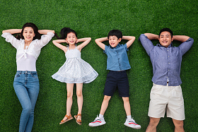 幸福的一家四口躺在草地上照片