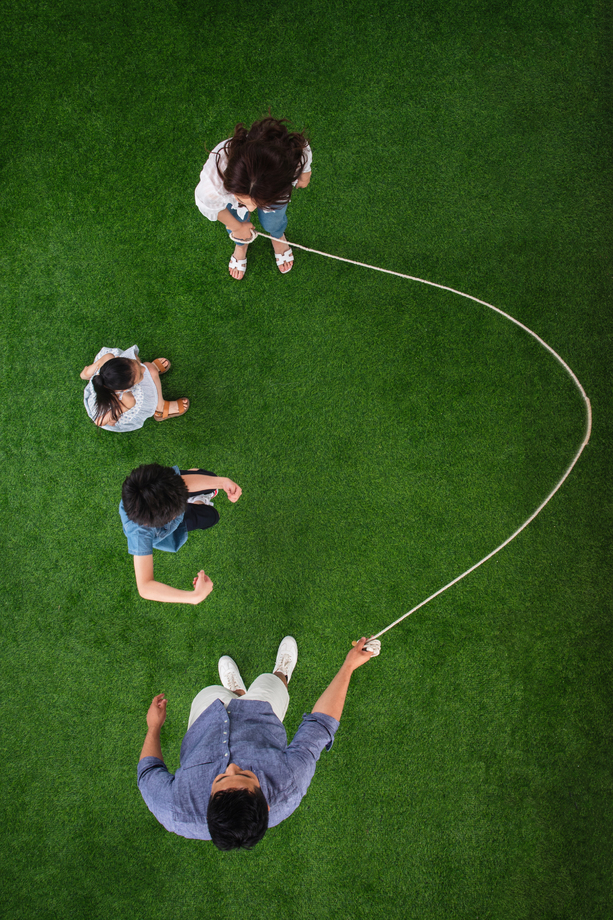 快乐的一家四口在草地上跳绳图片