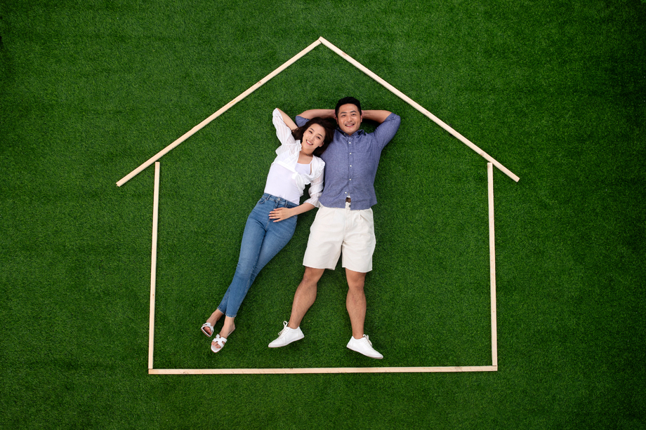 青年伴侣躺在草地上的房子轮廓 青年伴侣躺在草地上的房子轮廓