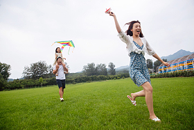 快乐的一家三口在草地上放风筝