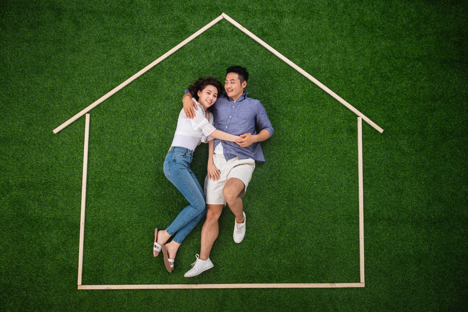 青年伴侣躺在草地上的房子轮廓 青年伴侣躺在草地上的房子轮廓