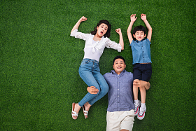 在草地上青年男人驮着妻子和儿子