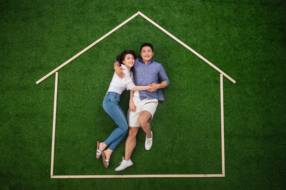 青年伴侣躺在草地上的房子轮廓 青年伴侣躺在草地上的房子轮廓