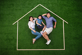 快乐的一家三口躺在草地上的房子轮廓