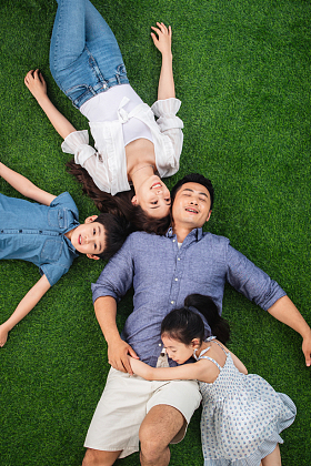 幸福的一家四口躺在草地上休息